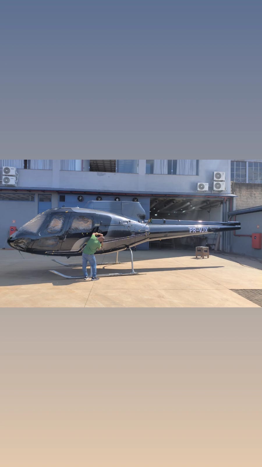 Helicóptero PR-VJX no pátio em frente ao hangar